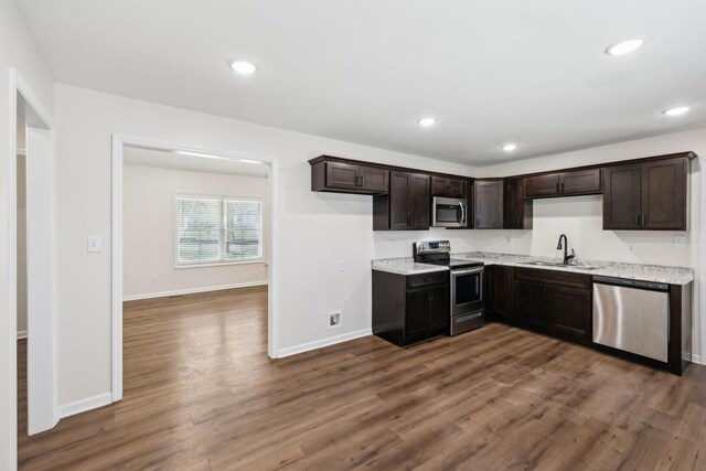 kitchen featuring dark wood-style flooring, recessed lighting, appliances with stainless steel finishes, a sink, and baseboards