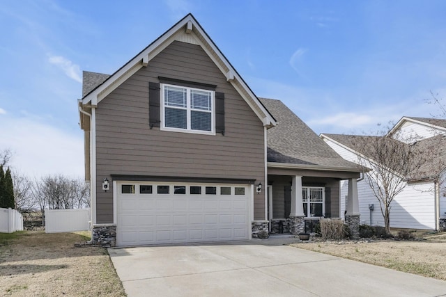 view of front of home with covered porch, stone siding, a shingled roof, and concrete driveway