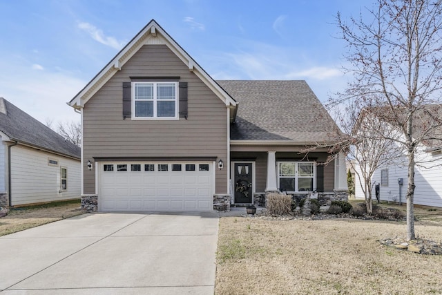 view of front of home with a shingled roof, an attached garage, a front yard, stone siding, and driveway