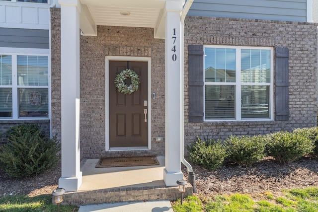 doorway to property with brick siding