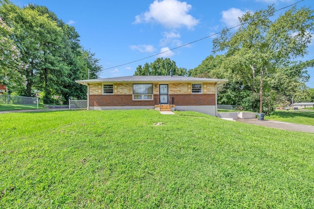 ranch-style house with a front yard, brick siding, fence, and driveway