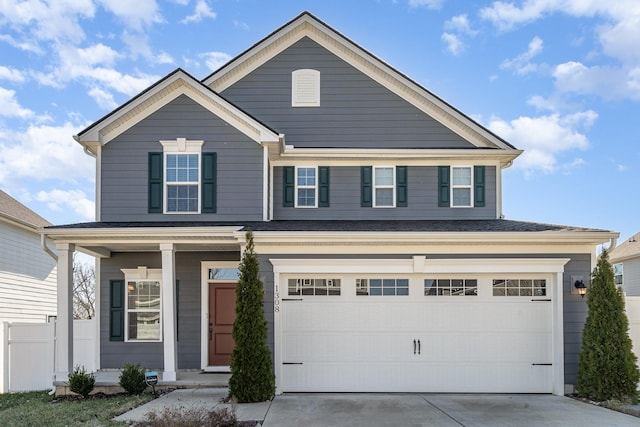 view of front facade with a garage, driveway, and fence