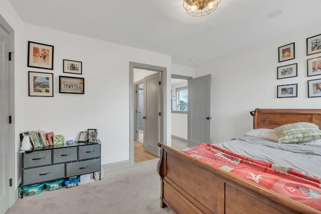 bedroom featuring light carpet and baseboards