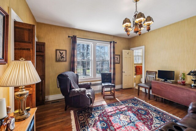 office space with a notable chandelier, dark wood-style flooring, visible vents, baseboards, and radiator