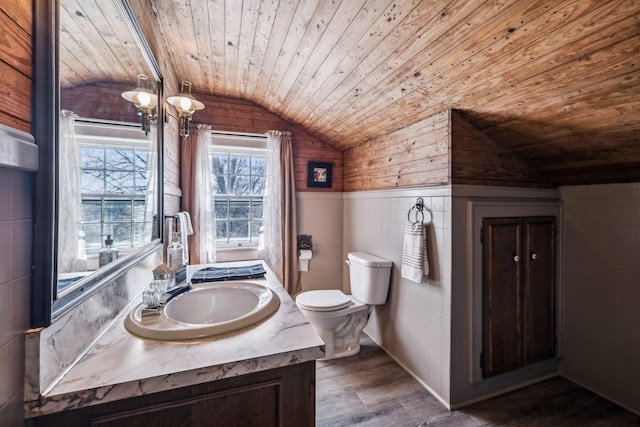 bathroom featuring lofted ceiling, toilet, wood ceiling, vanity, and wainscoting