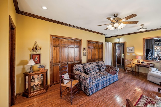 living room with ornamental molding, wood finished floors, a ceiling fan, and baseboards