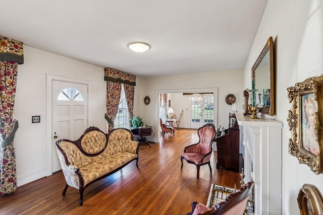 living area with baseboards and wood finished floors