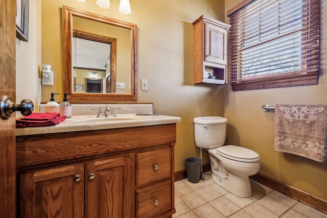 bathroom with baseboards, vanity, toilet, and tile patterned floors