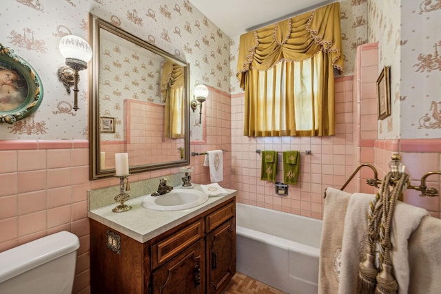 full bathroom with a garden tub, toilet, a wainscoted wall, vanity, and wallpapered walls