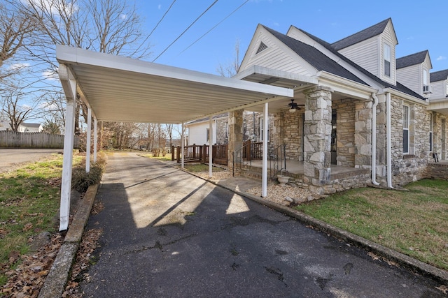 exterior space with a porch, fence, aphalt driveway, and a carport