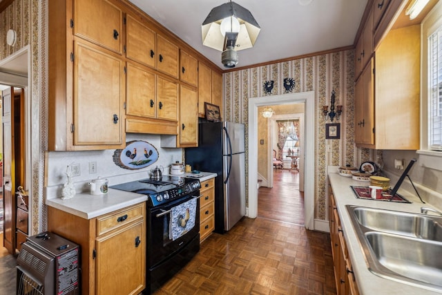 kitchen featuring light countertops, black range with electric cooktop, a sink, and wallpapered walls