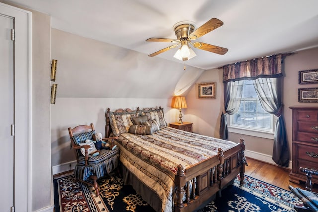 bedroom featuring lofted ceiling, ceiling fan, baseboards, and wood finished floors