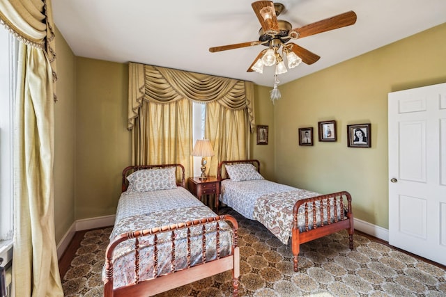 bedroom with ceiling fan and baseboards