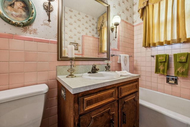 full bath featuring a tub, a wainscoted wall, tile walls, and wallpapered walls