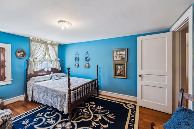 bedroom with dark wood-style flooring and baseboards