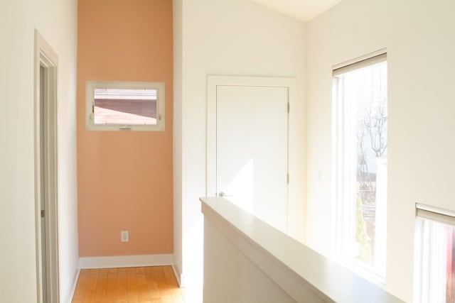 corridor featuring baseboards and wood finished floors