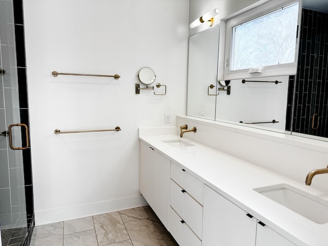 bathroom featuring double vanity, marble finish floor, baseboards, and a sink