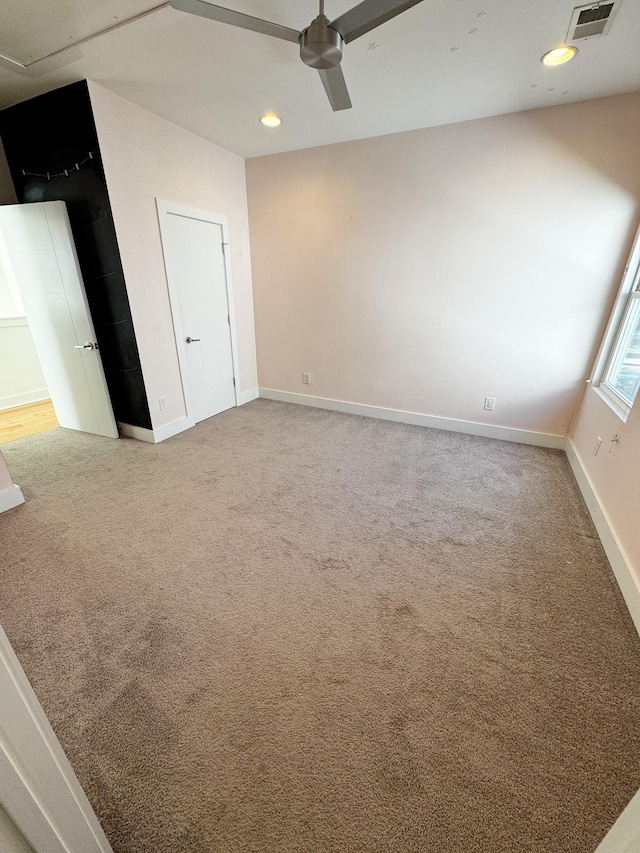 carpeted spare room with a ceiling fan, recessed lighting, visible vents, and baseboards