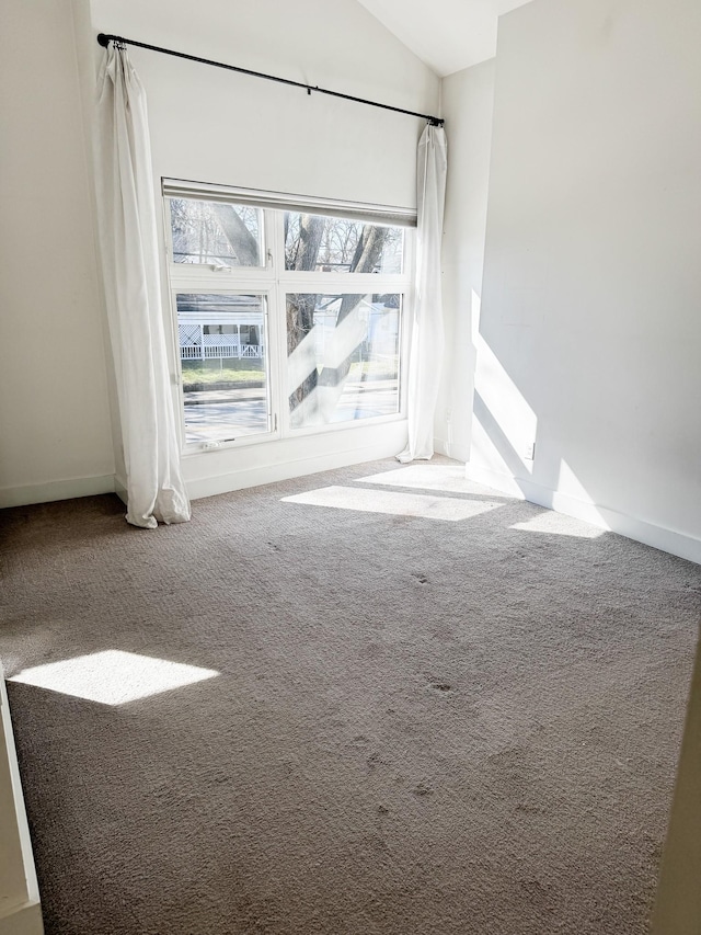 unfurnished room featuring vaulted ceiling and carpet floors