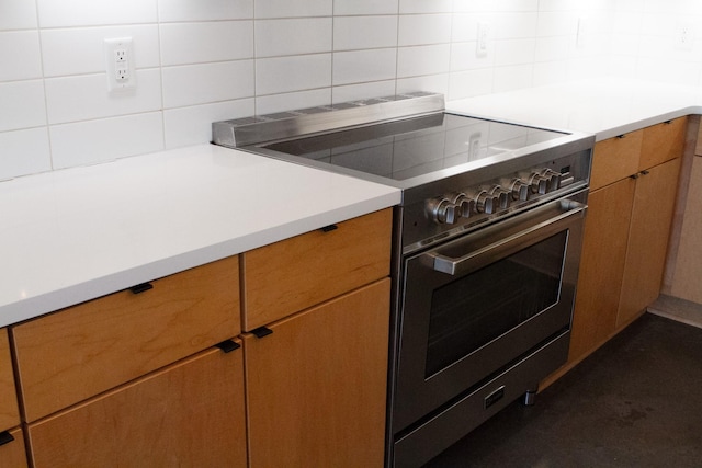 kitchen featuring light countertops, high end stainless steel range, and brown cabinets