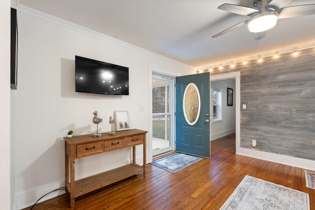 entryway featuring dark wood-style flooring, crown molding, visible vents, ceiling fan, and baseboards