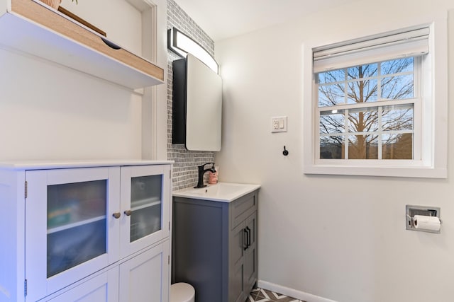 bathroom with backsplash, vanity, and baseboards