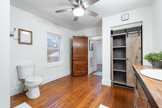 bathroom featuring ceiling fan, toilet, wood finished floors, visible vents, and vanity