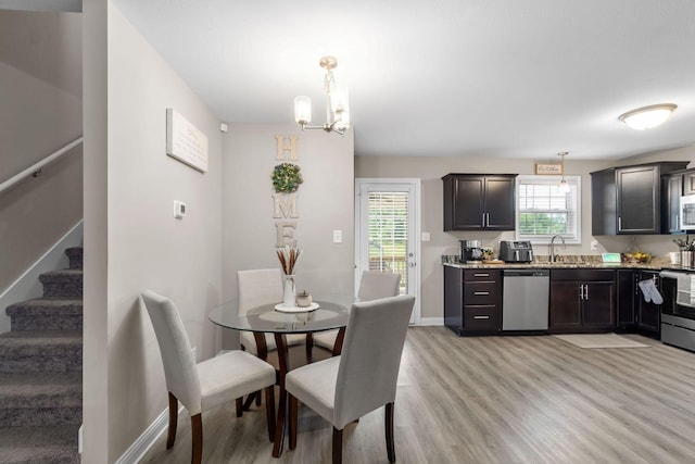 dining space with light wood-type flooring, stairs, baseboards, and a notable chandelier