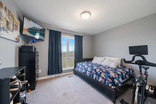 carpeted bedroom with visible vents, baseboards, and a textured ceiling