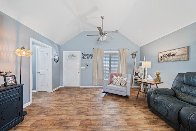 living area featuring a ceiling fan, lofted ceiling, baseboards, and wood finished floors