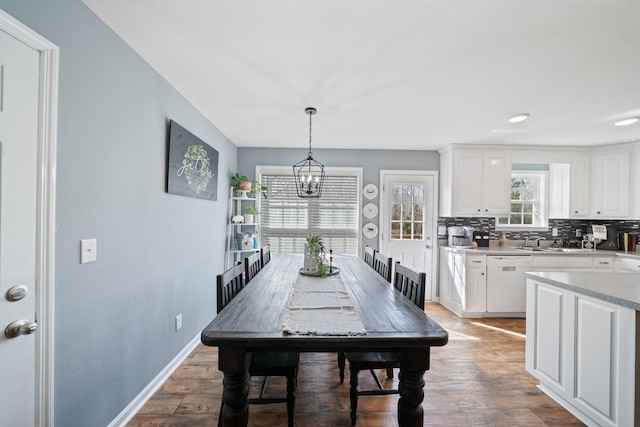 dining room with a chandelier, baseboards, and wood finished floors