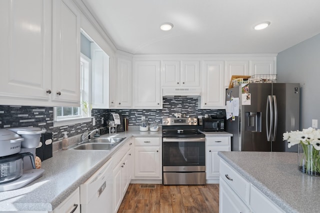 kitchen featuring under cabinet range hood, a sink, white cabinetry, light countertops, and appliances with stainless steel finishes