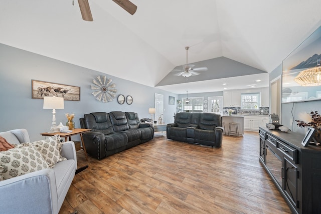 living area featuring vaulted ceiling, ceiling fan, and wood finished floors
