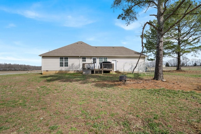 rear view of property with a deck, a shingled roof, crawl space, and a lawn