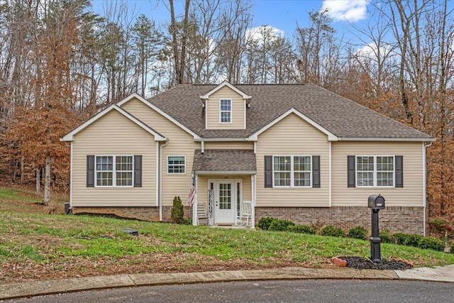 view of front facade featuring a shingled roof and a front lawn