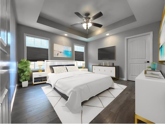 bedroom featuring dark wood-style floors, a tray ceiling, and baseboards