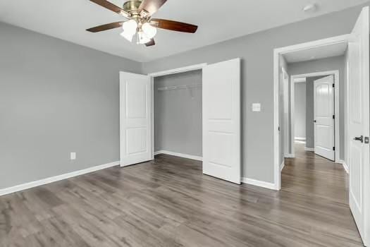 unfurnished bedroom featuring a closet, ceiling fan, baseboards, and wood finished floors