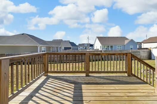 wooden terrace with a residential view and fence