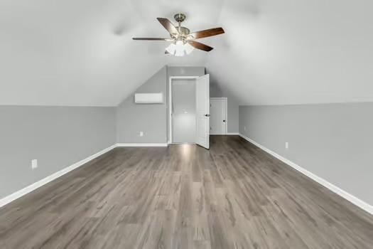 additional living space with vaulted ceiling, ceiling fan, wood finished floors, and baseboards