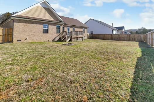 rear view of property with a deck, a yard, and a fenced backyard