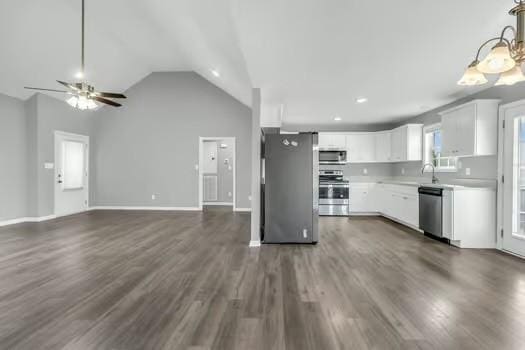 kitchen with stainless steel appliances, light countertops, dark wood-type flooring, open floor plan, and white cabinetry