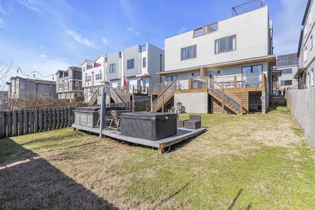 view of yard with a hot tub, a fenced backyard, a residential view, stairs, and a deck