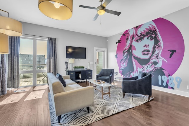 living room featuring wood finished floors, a ceiling fan, and baseboards