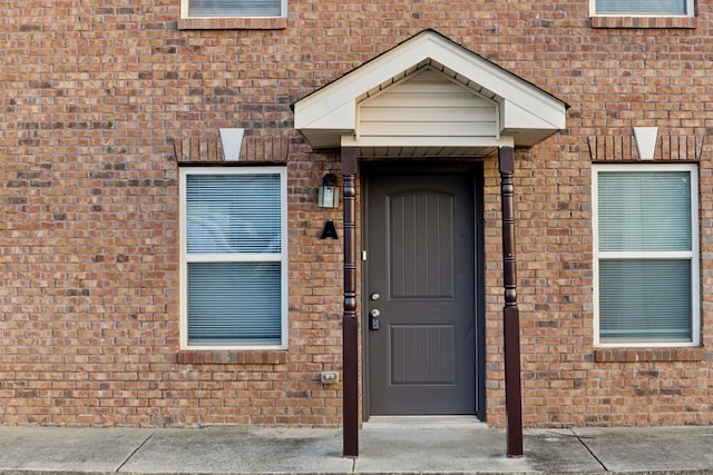 doorway to property featuring brick siding