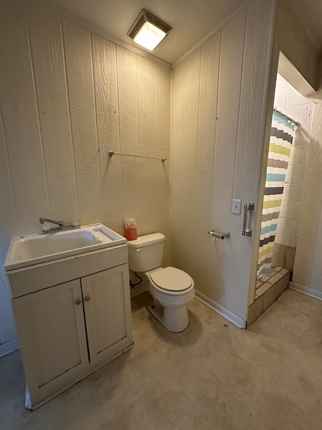 bathroom featuring wooden walls, toilet, vanity, and curtained shower