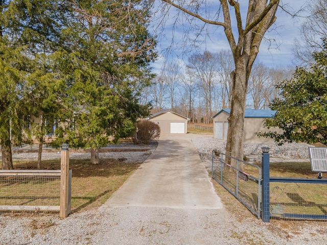 view of front of home featuring a garage, an outdoor structure, and fence