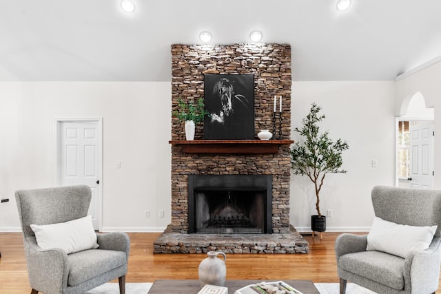 living area featuring recessed lighting, a fireplace, wood finished floors, and baseboards