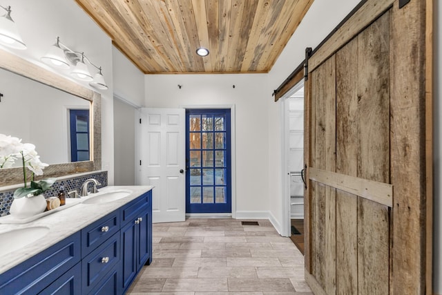 full bath with double vanity, baseboards, wood ceiling, wood finished floors, and a sink