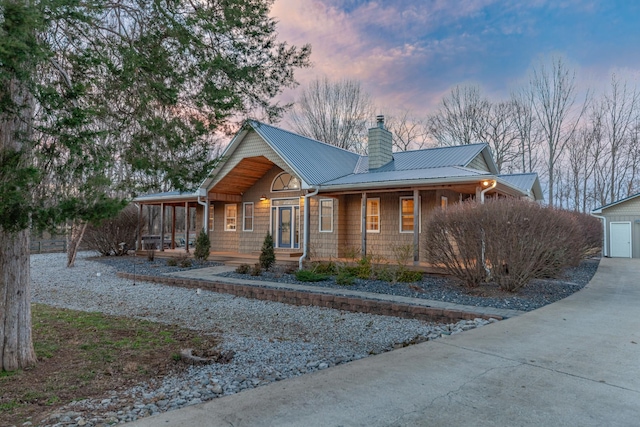 rustic home featuring a porch, metal roof, and a chimney