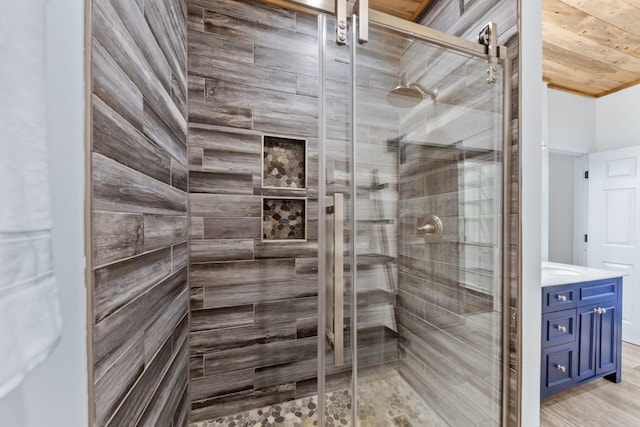 full bath with wood finished floors, a shower stall, and vanity